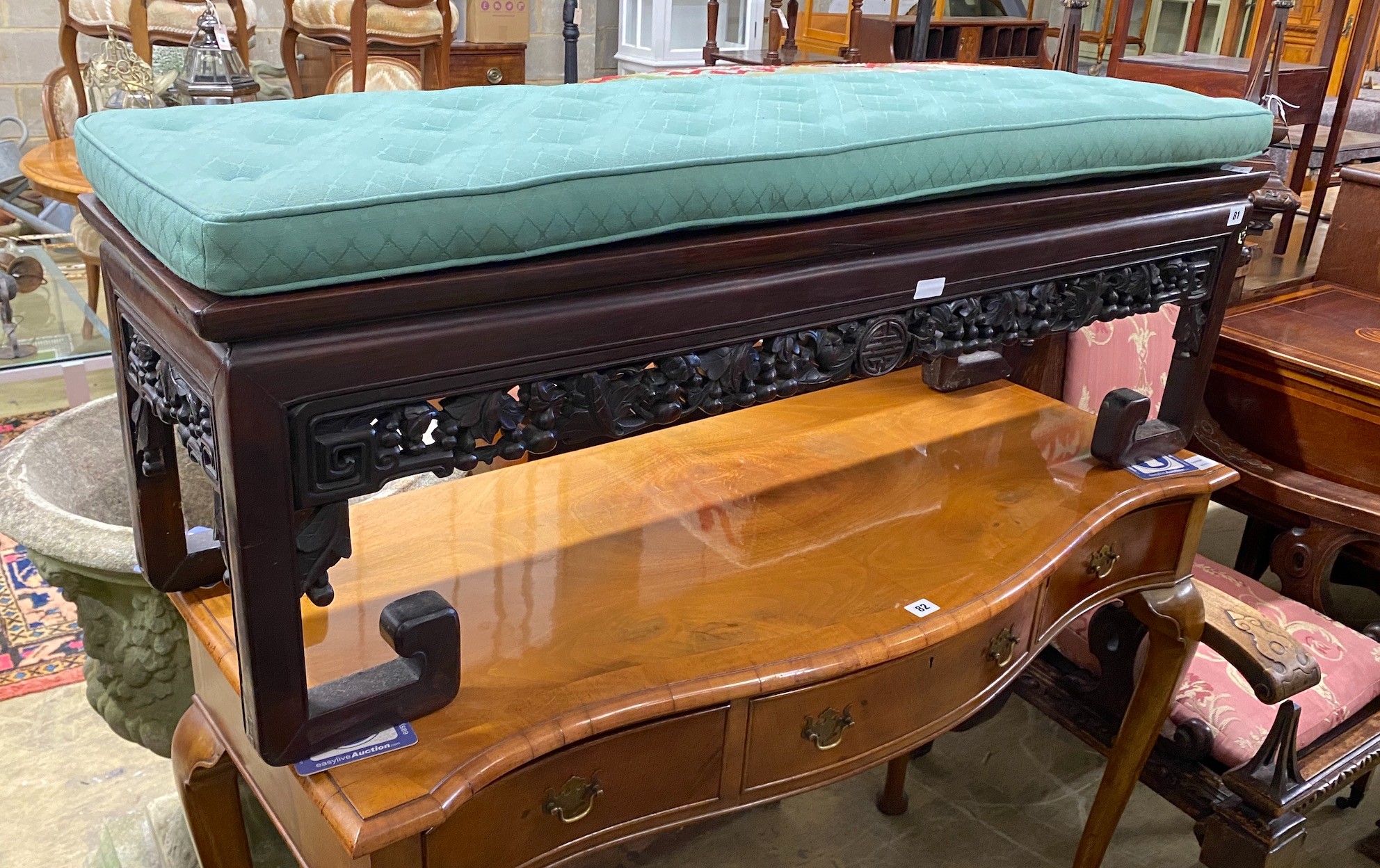 A Chinese hardwood bench, with carved and pierced frieze and buttoned squab seat, width 126cm, depth 36cm, height 37cm